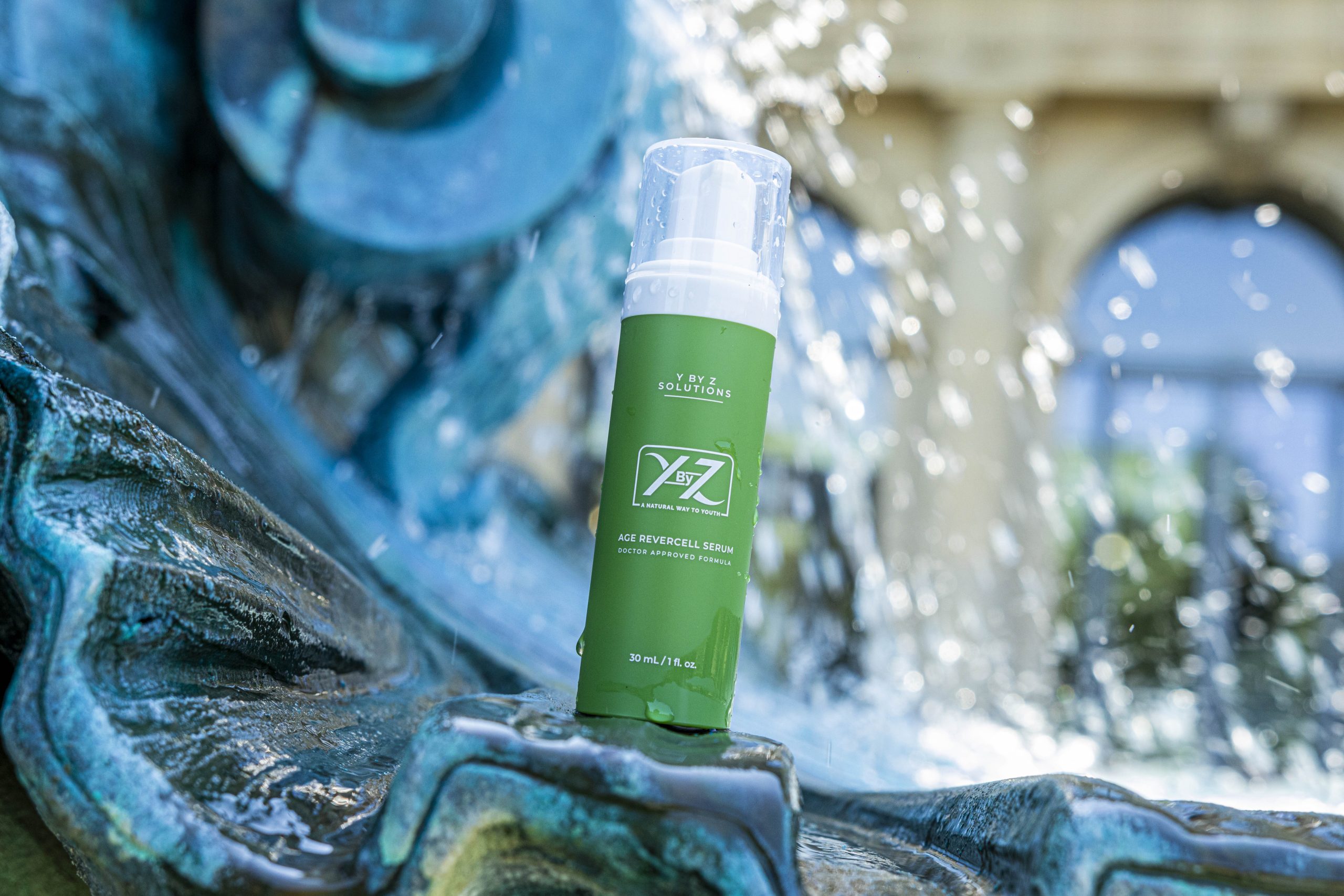 A bottle of green liquid sitting on top of a fountain.