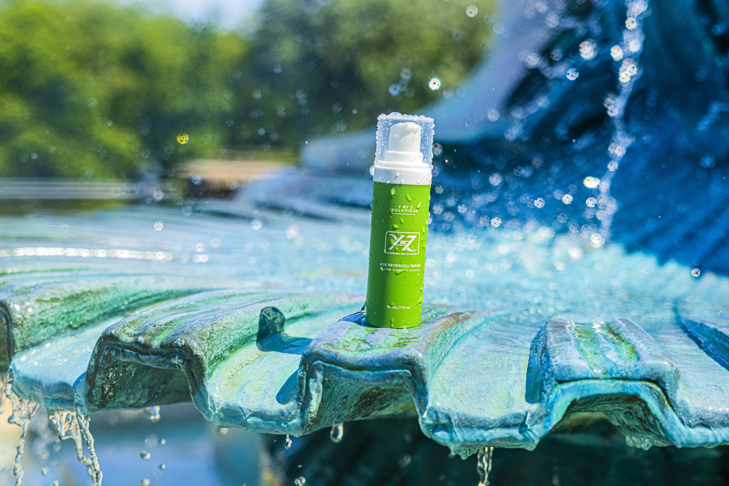 A green bottle sitting on top of a fountain.