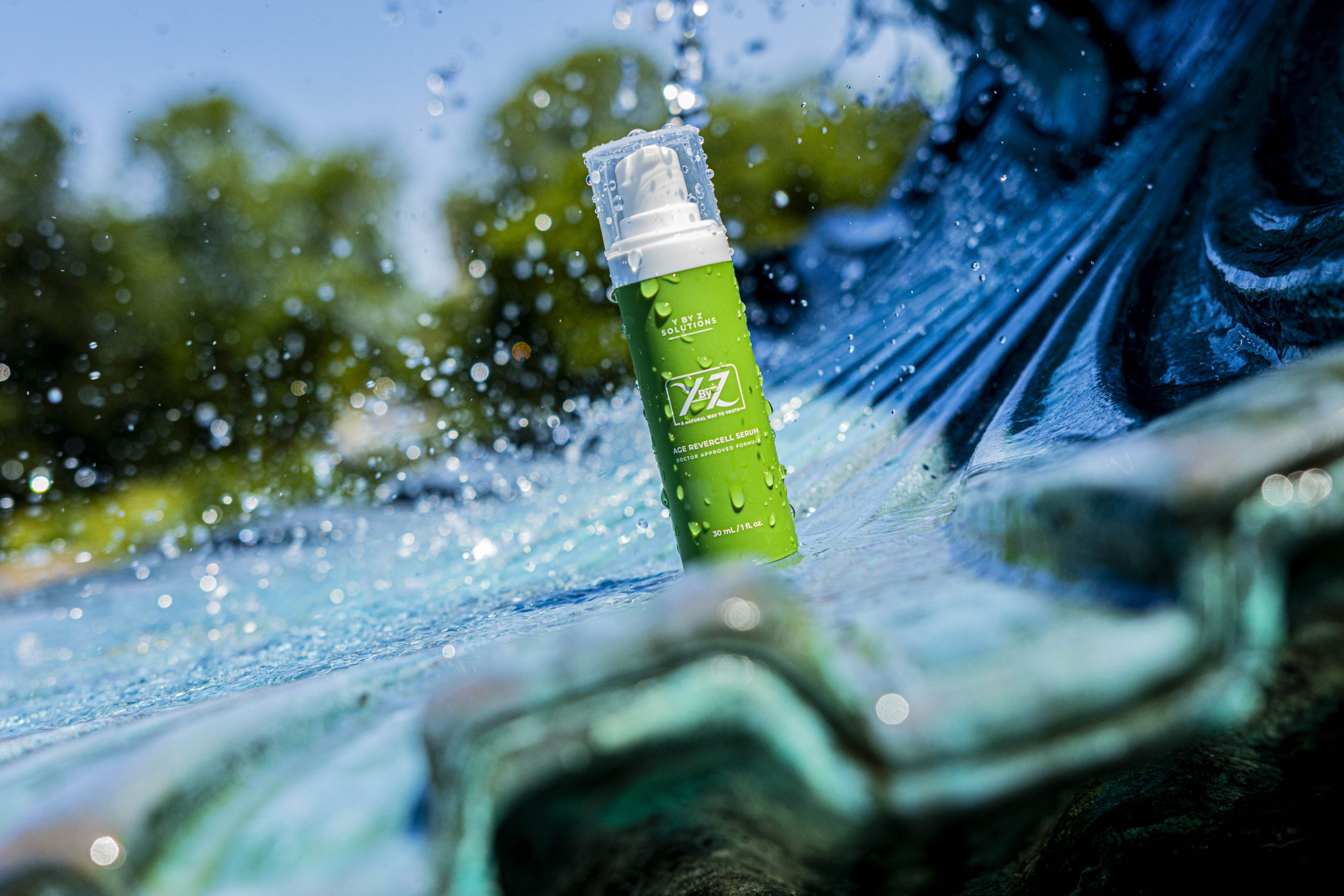 A green spray bottle is sitting in the water.