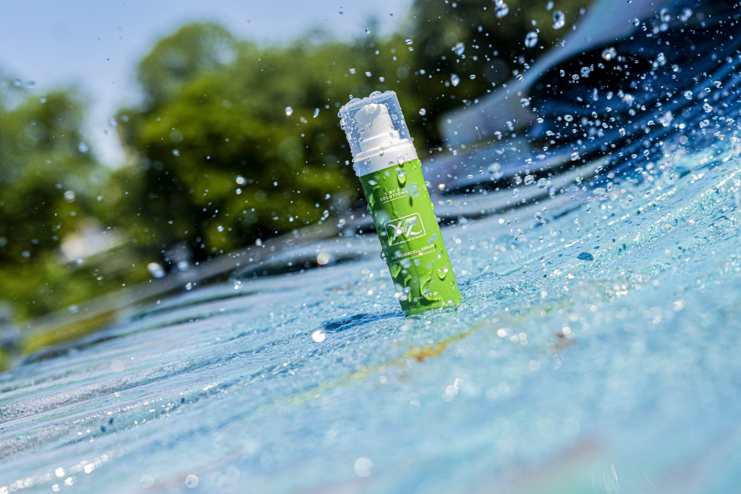 A green spray bottle sitting on top of the water.