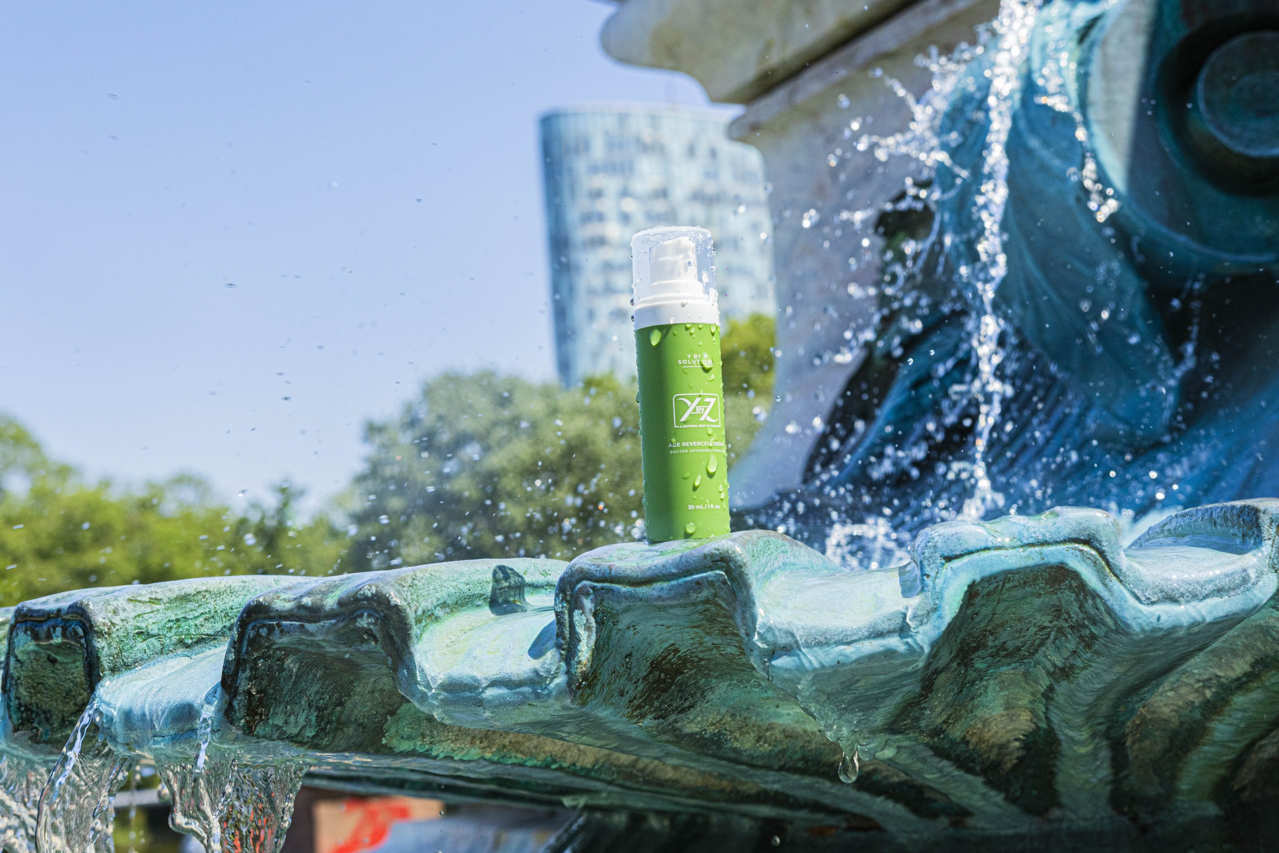 A green bottle is sitting on top of the fountain.