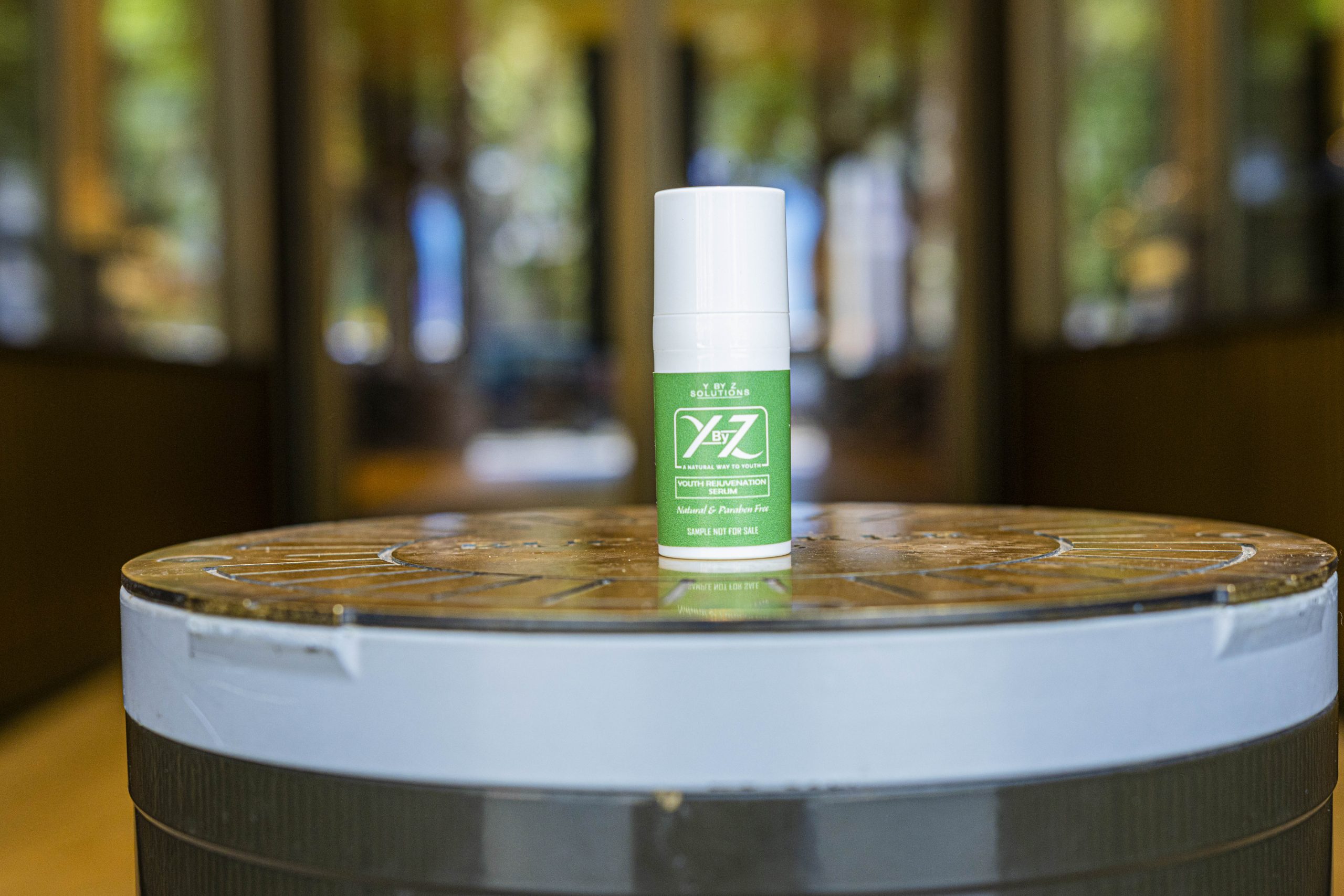 A bottle of green colored lotion sitting on top of a table.